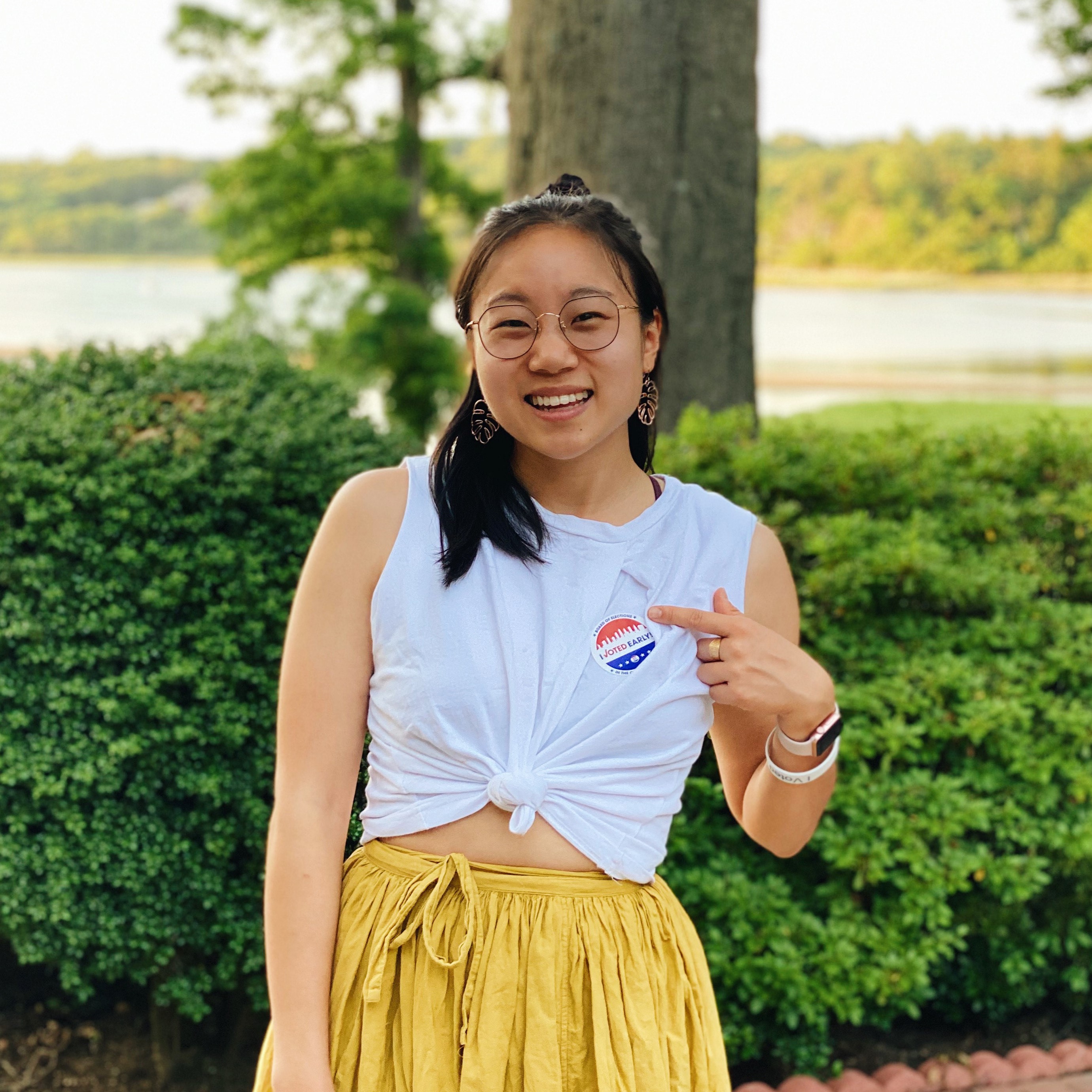 Woman pointing to "I Voted" sticket